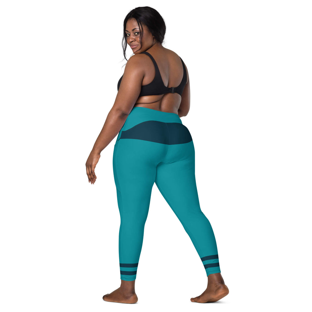 Model zeigt die türkisfarbenen Leggings mit hohem Bund und dunkelblauen Akzenten schräg von hinten.