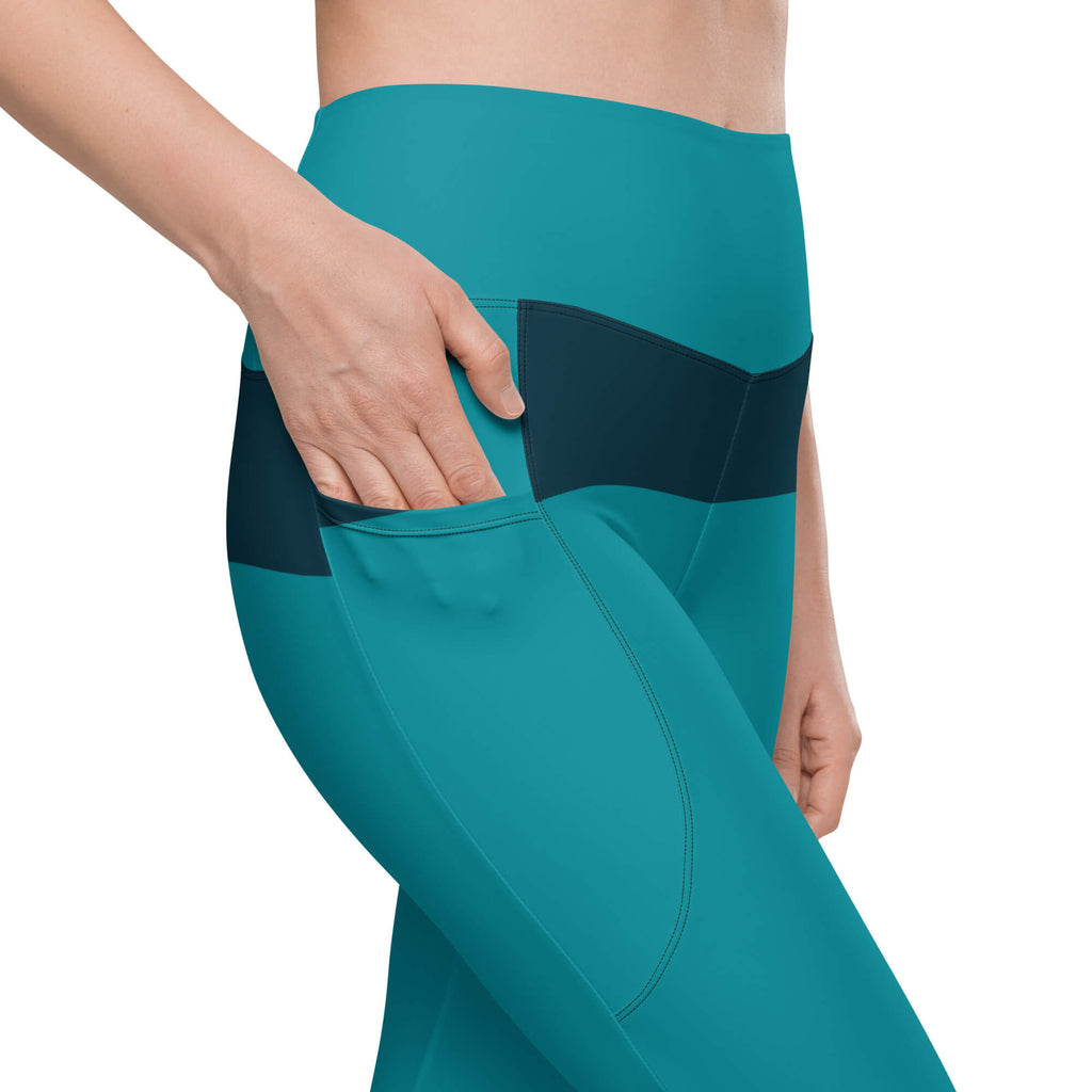 Nahaufnahme der Seitentasche der türkisfarbenen Leggings mit hineingesteckter Hand.