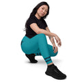 Model in hockender Pose mit türkisfarbenen Leggings und dunkelblauen Streifen an den Beinabschlüssen