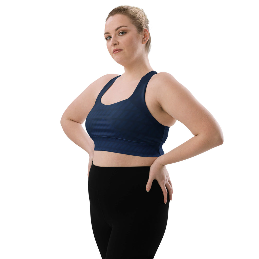 Model mit Händen an den Hüften: Dunkelblauer Longline-Sport-BH am Model, schräge Vorderansicht.